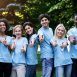 Confident young volunteers gesturing thumbs up at park